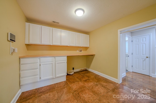 washroom featuring washer hookup, cabinets, and a textured ceiling