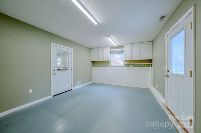 spare room featuring concrete floors and a textured ceiling