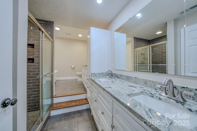 bathroom with vanity, a textured ceiling, toilet, and walk in shower