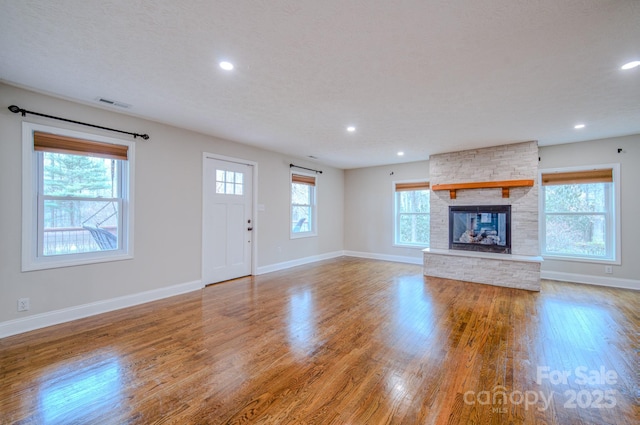 unfurnished living room featuring light wood-type flooring and a fireplace