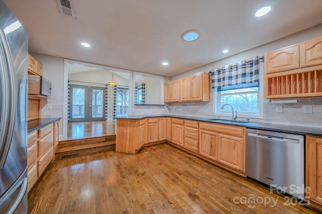 kitchen with stainless steel appliances, plenty of natural light, sink, and hardwood / wood-style floors