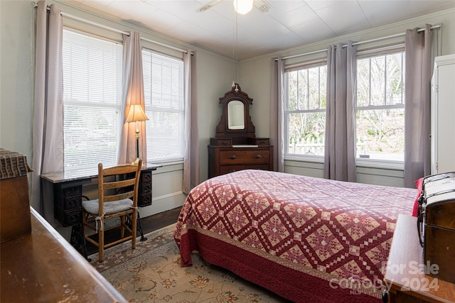 bedroom featuring hardwood / wood-style flooring, ceiling fan, multiple windows, and crown molding