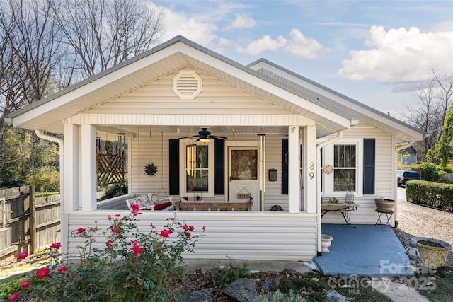 view of front of house featuring a porch, a ceiling fan, and fence