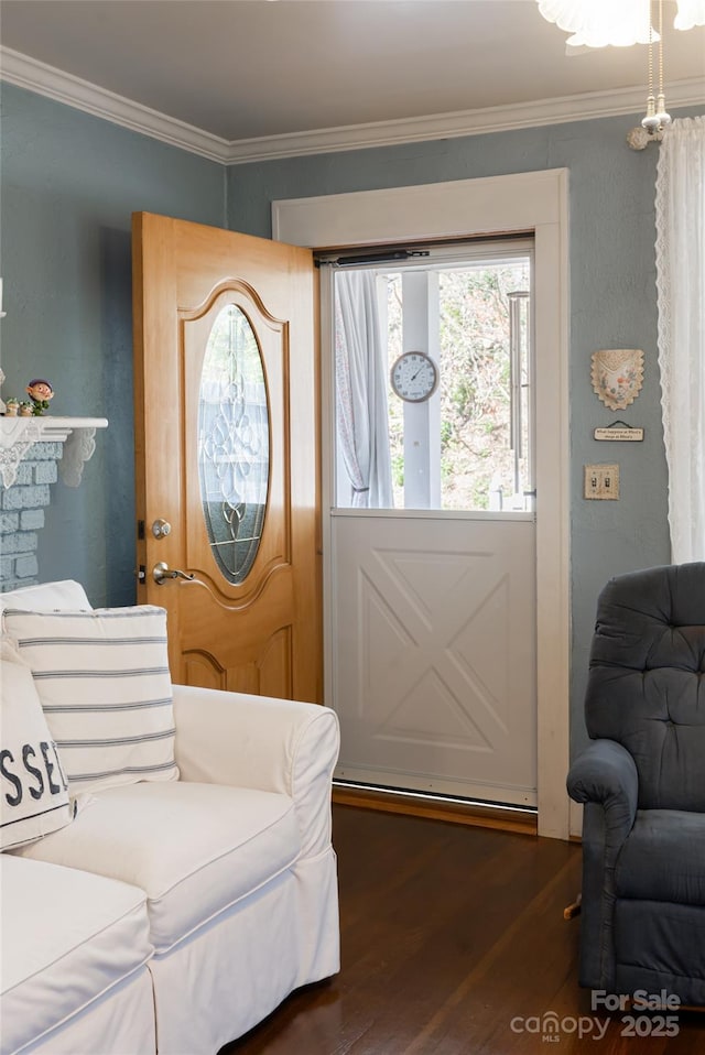 foyer with dark wood-type flooring and crown molding