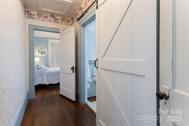 corridor with dark wood finished floors and wallpapered walls
