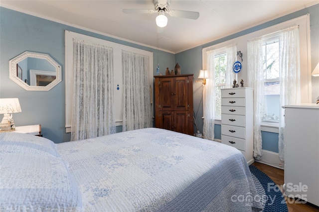 bedroom with crown molding, ceiling fan, and wood finished floors