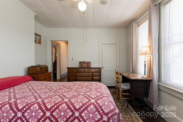 bedroom with multiple windows, wood finished floors, and crown molding