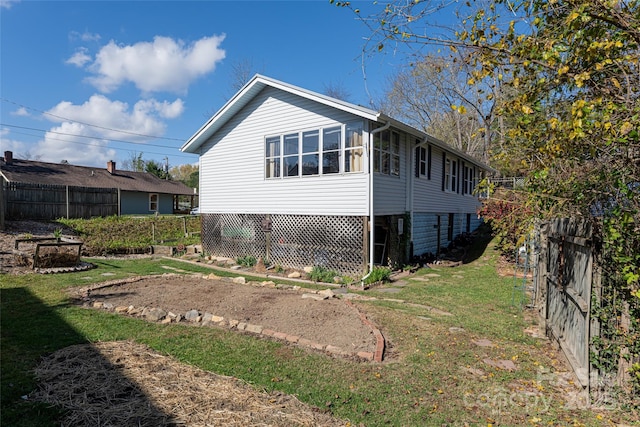 view of property exterior featuring fence and a lawn