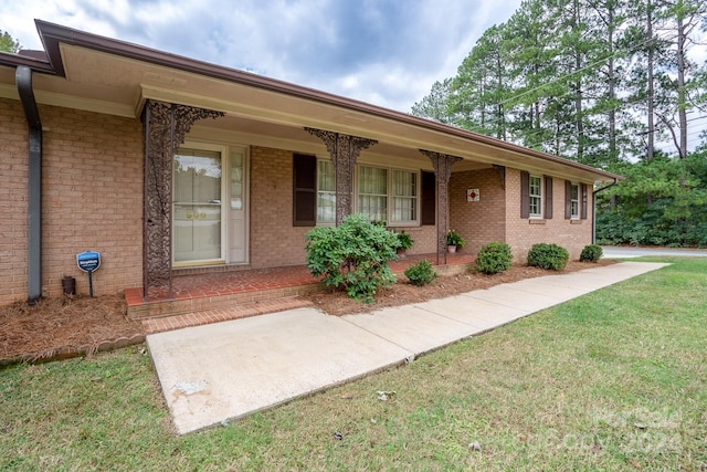 ranch-style house featuring a porch and a front lawn