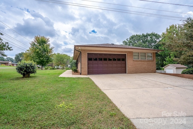 view of front of property featuring a front yard, a garage, and an outdoor structure