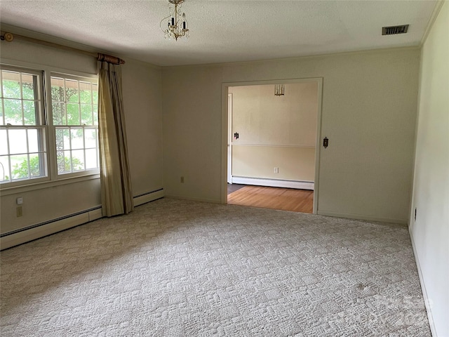 carpeted spare room with a textured ceiling and baseboard heating