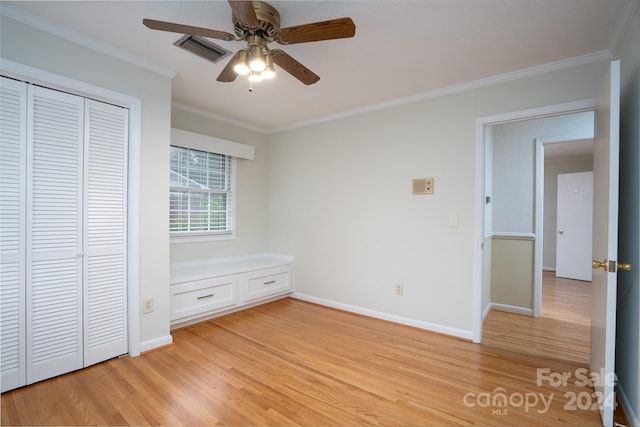 unfurnished bedroom with ceiling fan, light hardwood / wood-style flooring, crown molding, and a closet