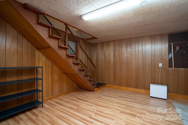 basement with wooden walls and hardwood / wood-style floors