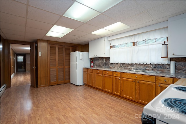 kitchen featuring sink, white appliances, tasteful backsplash, light hardwood / wood-style flooring, and a paneled ceiling