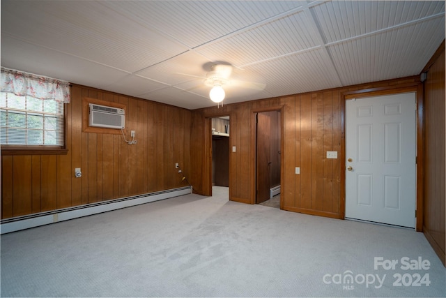 interior space featuring light colored carpet, a baseboard radiator, wood walls, and a wall mounted AC