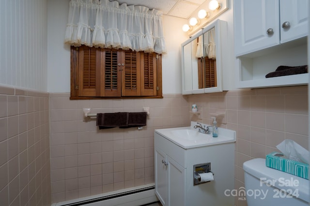 bathroom featuring tile walls, a baseboard heating unit, vanity, and toilet