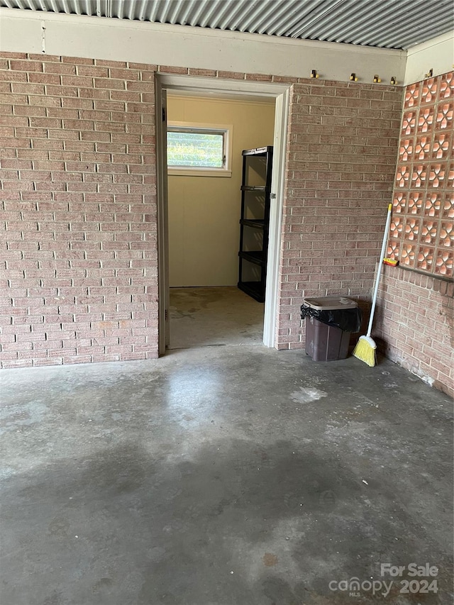 empty room with brick wall and concrete flooring