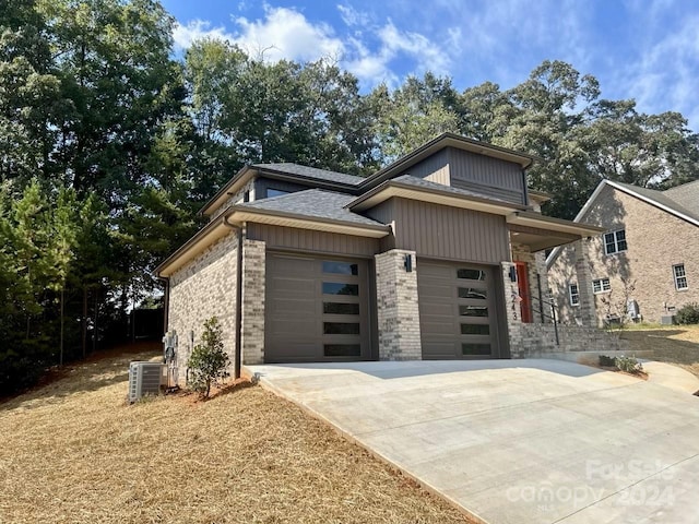 view of front of home with central AC unit and a garage