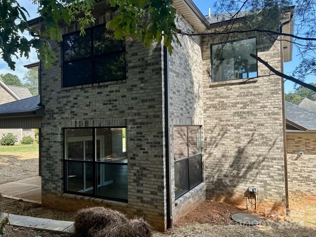 1243 10th Street Pl NW, Hickory, NC 28601 - view of side of home with brick siding and a shingled roof