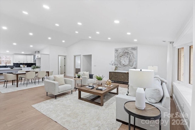 living room with lofted ceiling and light wood-type flooring