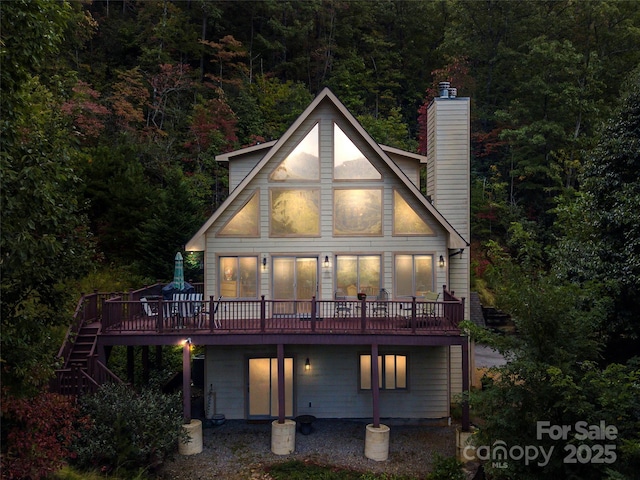 rear view of property featuring a wooden deck