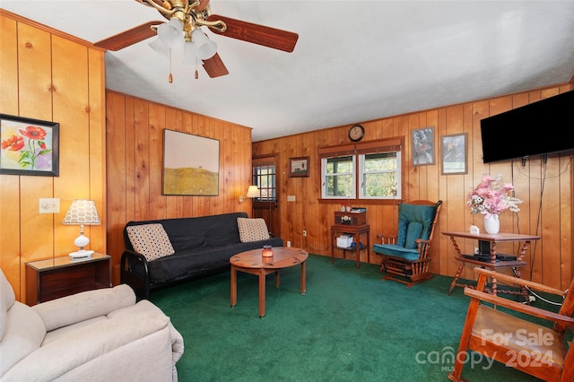 living room featuring wood walls, dark colored carpet, and ceiling fan