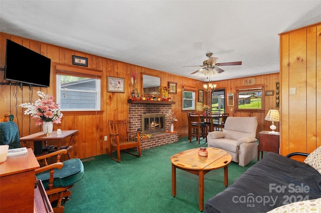 carpeted living room featuring a brick fireplace, wood walls, and ceiling fan