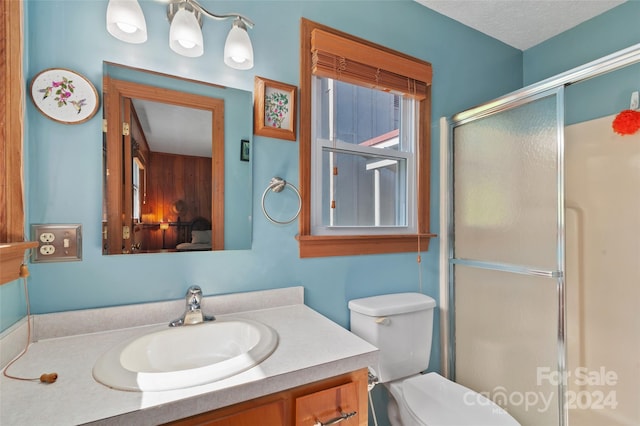 bathroom with vanity, walk in shower, toilet, and a textured ceiling