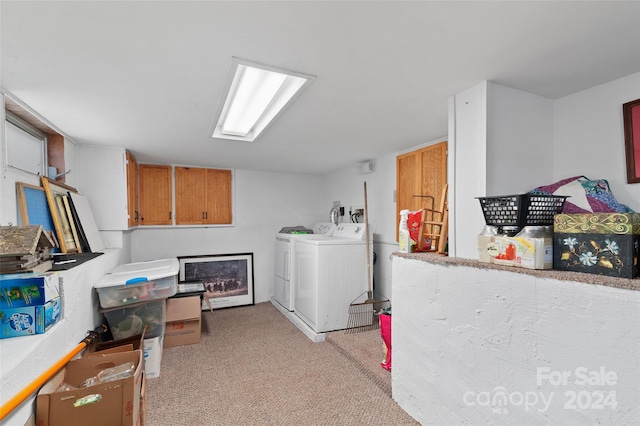 clothes washing area featuring washer and dryer, cabinets, and light carpet