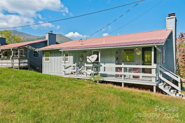 rear view of house featuring a lawn and a mountain view