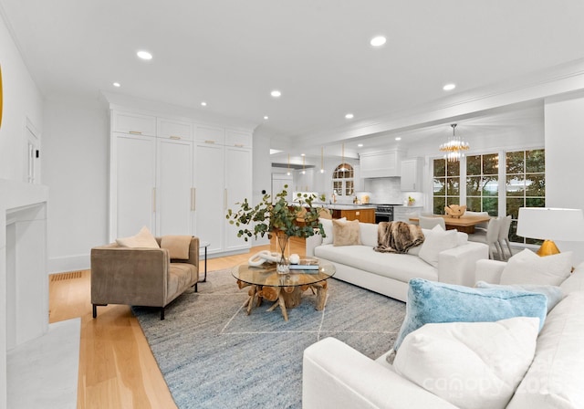 living room with an inviting chandelier and light wood-type flooring