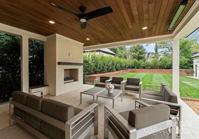 view of patio with ceiling fan and an outdoor living space with a fireplace