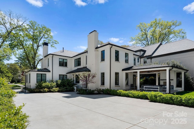 rear view of property with ceiling fan and a patio area