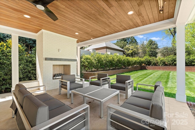 view of patio with ceiling fan and an outdoor living space with a fireplace