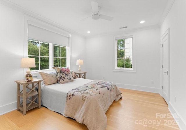 bedroom featuring crown molding, wood-type flooring, and ceiling fan