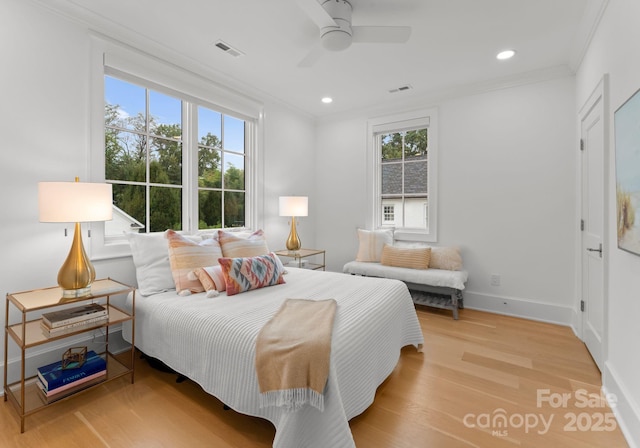 bedroom featuring ornamental molding, light hardwood / wood-style floors, and ceiling fan