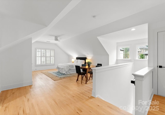 interior space with multiple windows, wood-type flooring, and vaulted ceiling