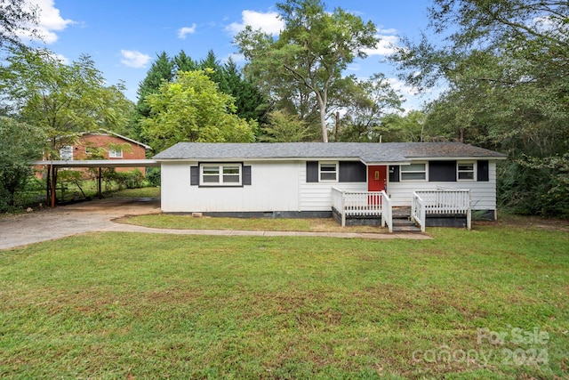 ranch-style home featuring a carport and a front yard