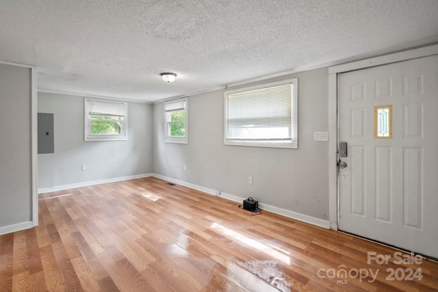 entryway featuring light hardwood / wood-style floors, electric panel, and a textured ceiling