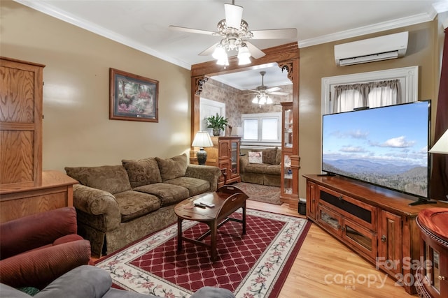 living room with a wall mounted AC, light wood-type flooring, ornamental molding, and ceiling fan