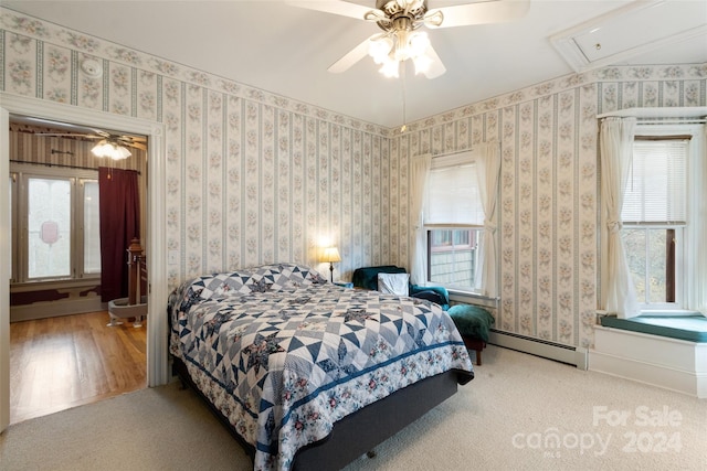 bedroom featuring hardwood / wood-style flooring, ceiling fan, and multiple windows