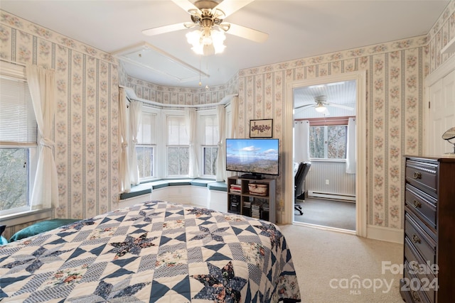 carpeted bedroom with ceiling fan and a baseboard radiator