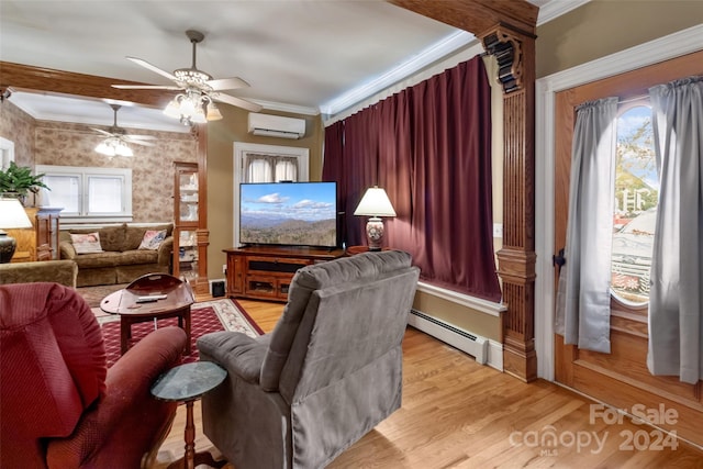 cinema room with light hardwood / wood-style floors, baseboard heating, ceiling fan, crown molding, and an AC wall unit