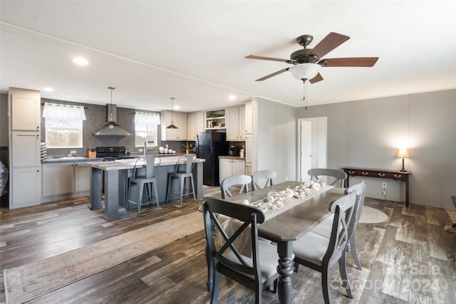 dining area with dark hardwood / wood-style flooring, ceiling fan, and sink