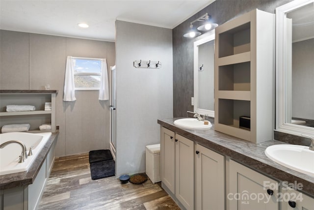 bathroom featuring hardwood / wood-style floors, vanity, and plus walk in shower