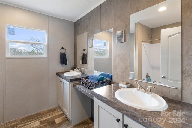 bathroom with walk in shower, a wealth of natural light, vanity, and hardwood / wood-style flooring