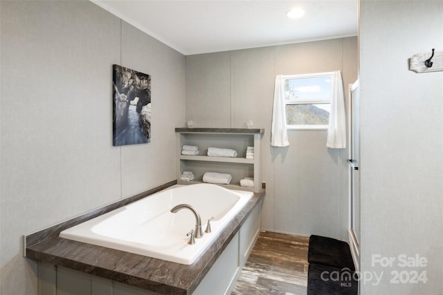 bathroom featuring hardwood / wood-style flooring and a tub to relax in