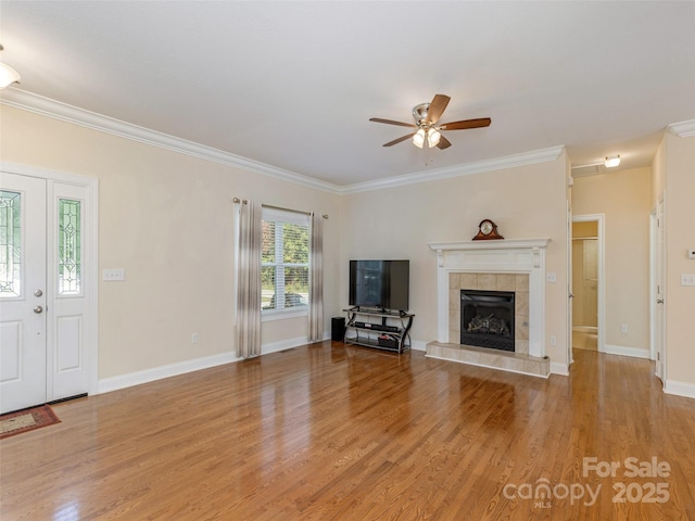 unfurnished living room featuring baseboards, ceiling fan, ornamental molding, light wood-type flooring, and a fireplace