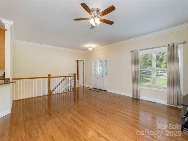 interior space with ornamental molding, visible vents, and wood finished floors