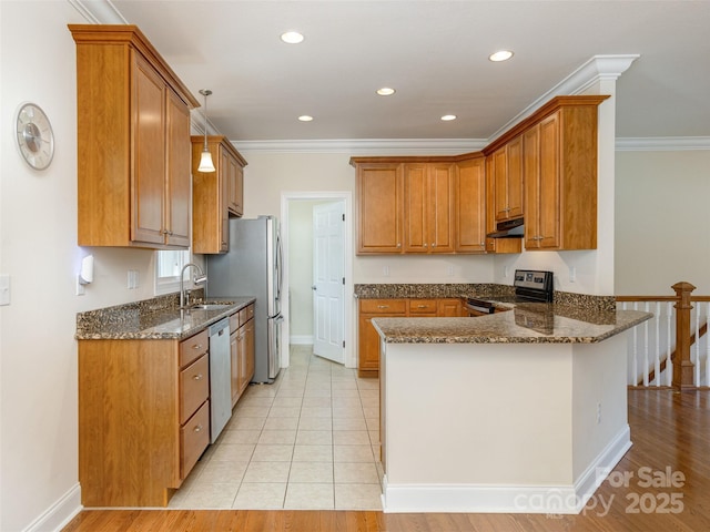 kitchen with dark stone countertops, stainless steel appliances, ornamental molding, and a peninsula